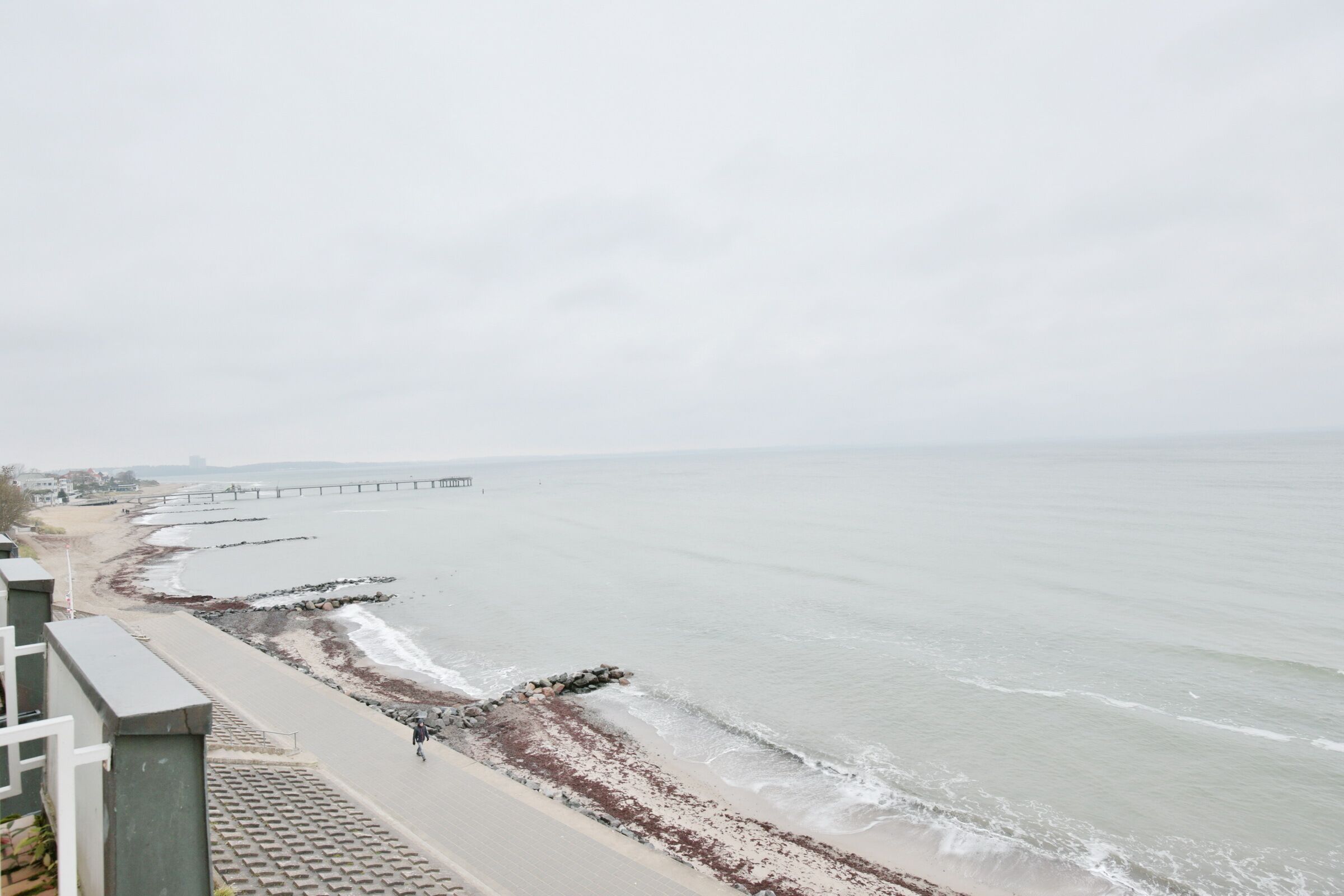 Une vue sur la côte, avec une plage, une jetée et un mur de pierres.