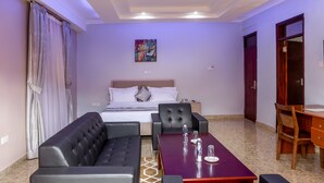 Una camera d'albergo con un letto, un divano, un tavolo da pranzo e una scrivania.