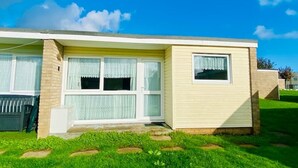 Une maison de plain-pied avec un garage à l’avant, un petit porche et une pelouse bien entretenue.