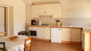 A kitchen with white cabinets, a coffee maker, a kettle, and a dishwasher. - Beautiful manor with swimming pool in front of the Provençal Colorado (Rustrel)