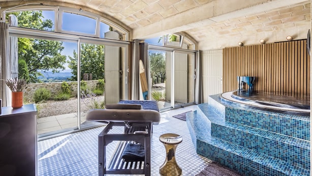 A spa area with a hot tub, a massage table, and a view of the outdoors. - Exceptional Luberon location - Private swimming pool (Cucuron)
