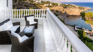 A balcony with wicker furniture and a view of the sea and rocky landscape. - A seafront villa with swimming pool (Achlia)