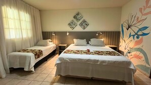Una habitación de hotel con dos camas, un amplio mural floral y una lámpara en el techo.