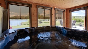 Een hottub met uitzicht op een meer en een terras.
