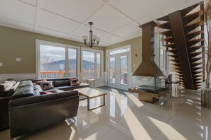 A spacious living area with a sofa, coffee table, and a fireplace.