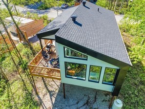 A modern house with a deck, large windows, and a sloped roof. - Eau Vive - Nature Escape near Quebec City (Pont-Rouge)
