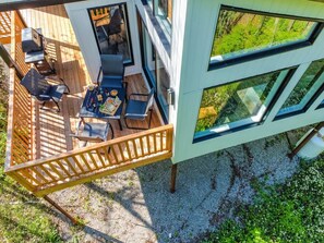 Une terrasse extérieure moderne, dotée d’un espace repas comprenant des chaises et une table.