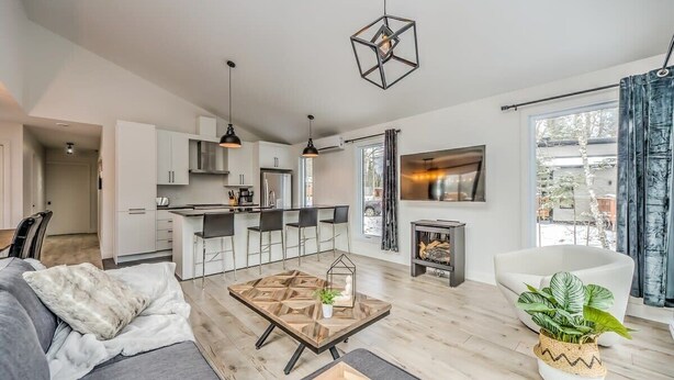 Un salon moderne avec un canapé, une table basse et un coin repas avec des chaises.