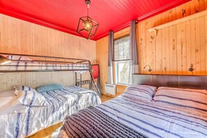 A room with bunk beds, a window with curtains, a radiator, and a hanging light fixture. - Gingo Shack - Private Spa & Lake View (Saint-Ferdinand)