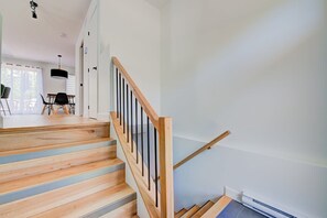Stairs lead to a spacious upper floor with a dining area.