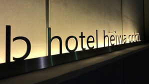 Une enseigne d’hôtel portant le nom « Hotel Heiwa Odori » est illuminée.
