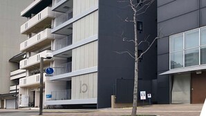 Un immeuble moderne à plusieurs étages, doté de balcons et d’une enseigne indiquant le mot « ORIENT ».