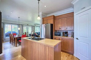 A kitchen with wooden cabinets, a stainless steel refrigerator, and a microwave.