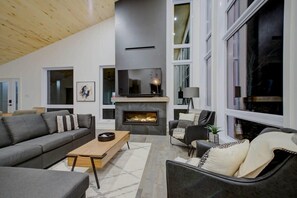 Una sala de estar moderna con chimenea, un sofá, una mesa de centro y un televisor.