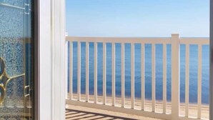Un balcó amb barana blanca davant d'una platja.