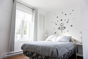 A bedroom with a bed, a window, and a wall decal. - Les Quatre Vents - Lakefront & Private Beach (Saint-Félicien)