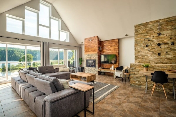 A spacious living room with a large sectional sofa, a fireplace, and a stone accent wall.