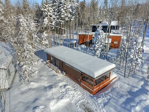 A cabin with a large windowed room, surrounded by snow-covered trees. - Le Shalom - Nature & Relax in Pont-Rouge (Pont-Rouge)