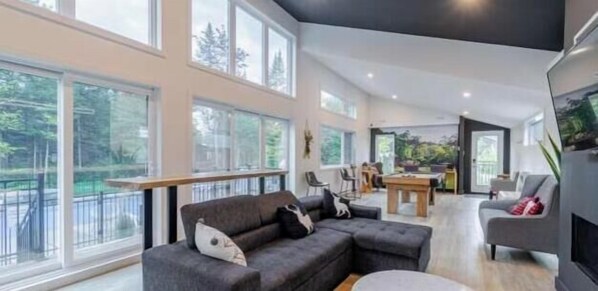 A modern living room with a sofa, a dining table, and a fireplace.
