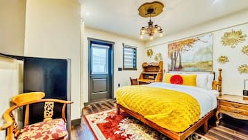 A bedroom with a bed, a wooden chair, a desk, and a bookshelf.