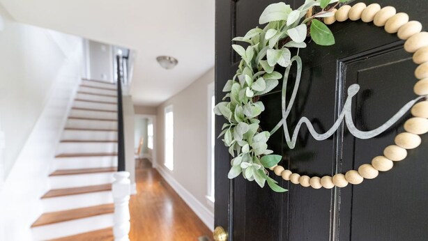 A black door with a wooden bead garland and a green leafy wreath. - Edenton Historic District, Walk Downtown, Dogs Welcome, Fenced Yard! (Edenton)