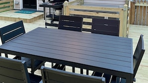A covered outdoor patio with a table and chairs, a grill, and string lights. - Edenton Historic District, Walk Downtown, Dogs Welcome, Fenced Yard! (Edenton)