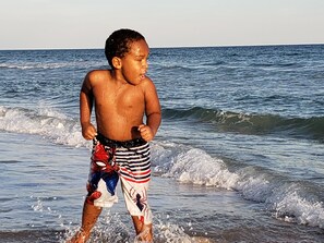 Ein Kind spielt im Wasser am Strand.