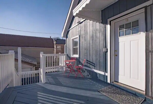 Guests can enjoy a front porch with a table and chairs.