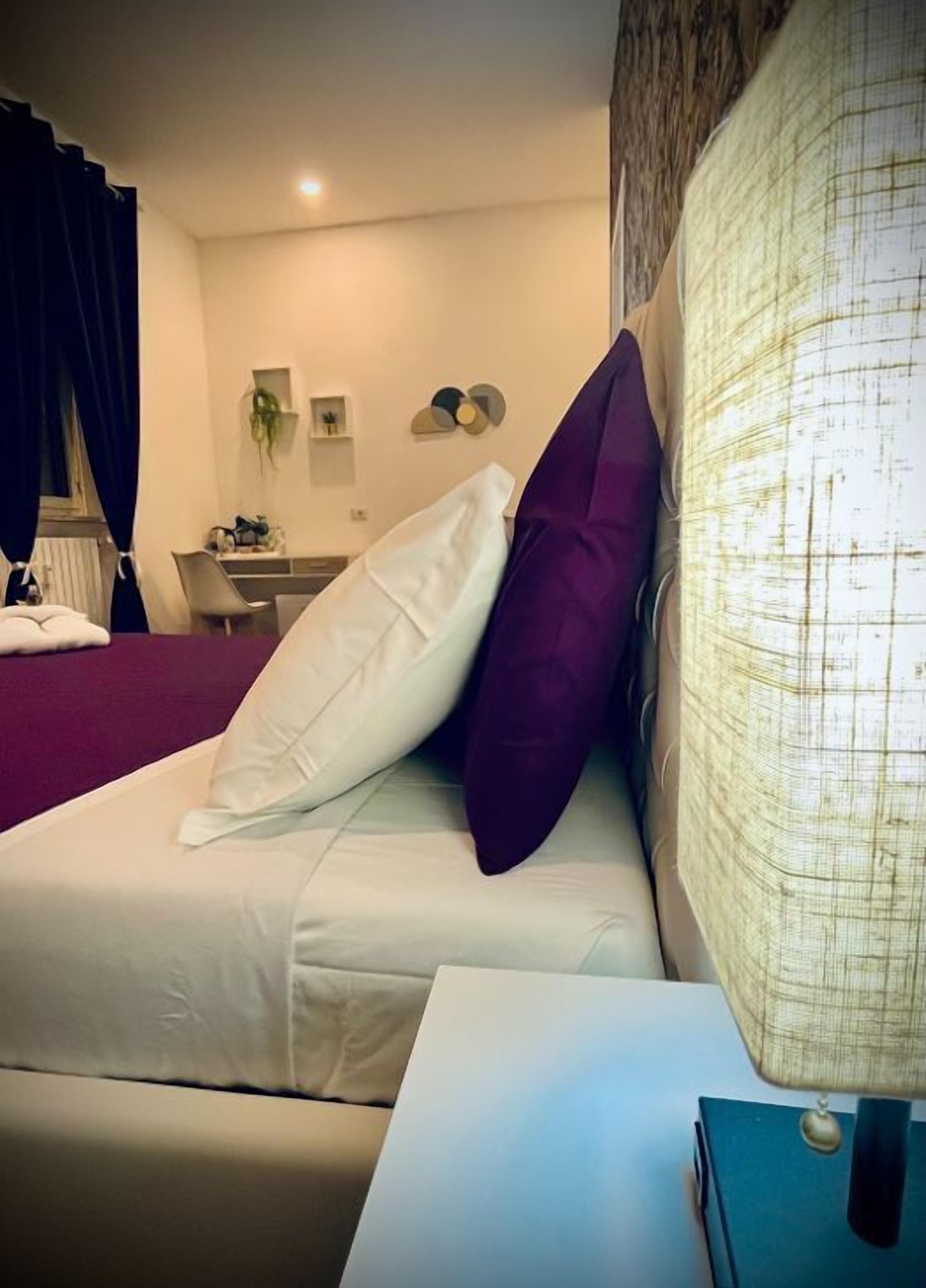 Une chambre d’hôtel avec un lit, un bureau, une lampe et une chaise.