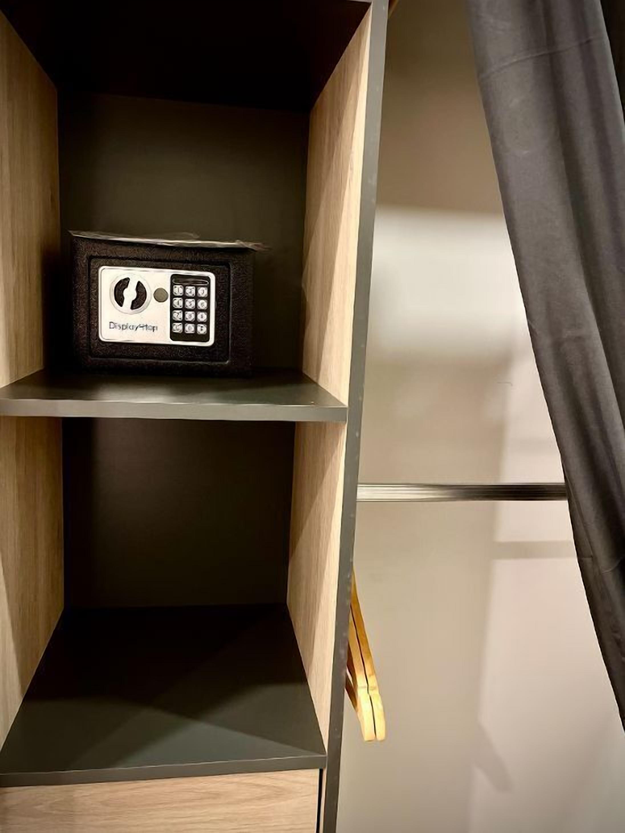 A modern, minimalist room with a built-in display panel on a shelf, a wooden door, and a curtain.