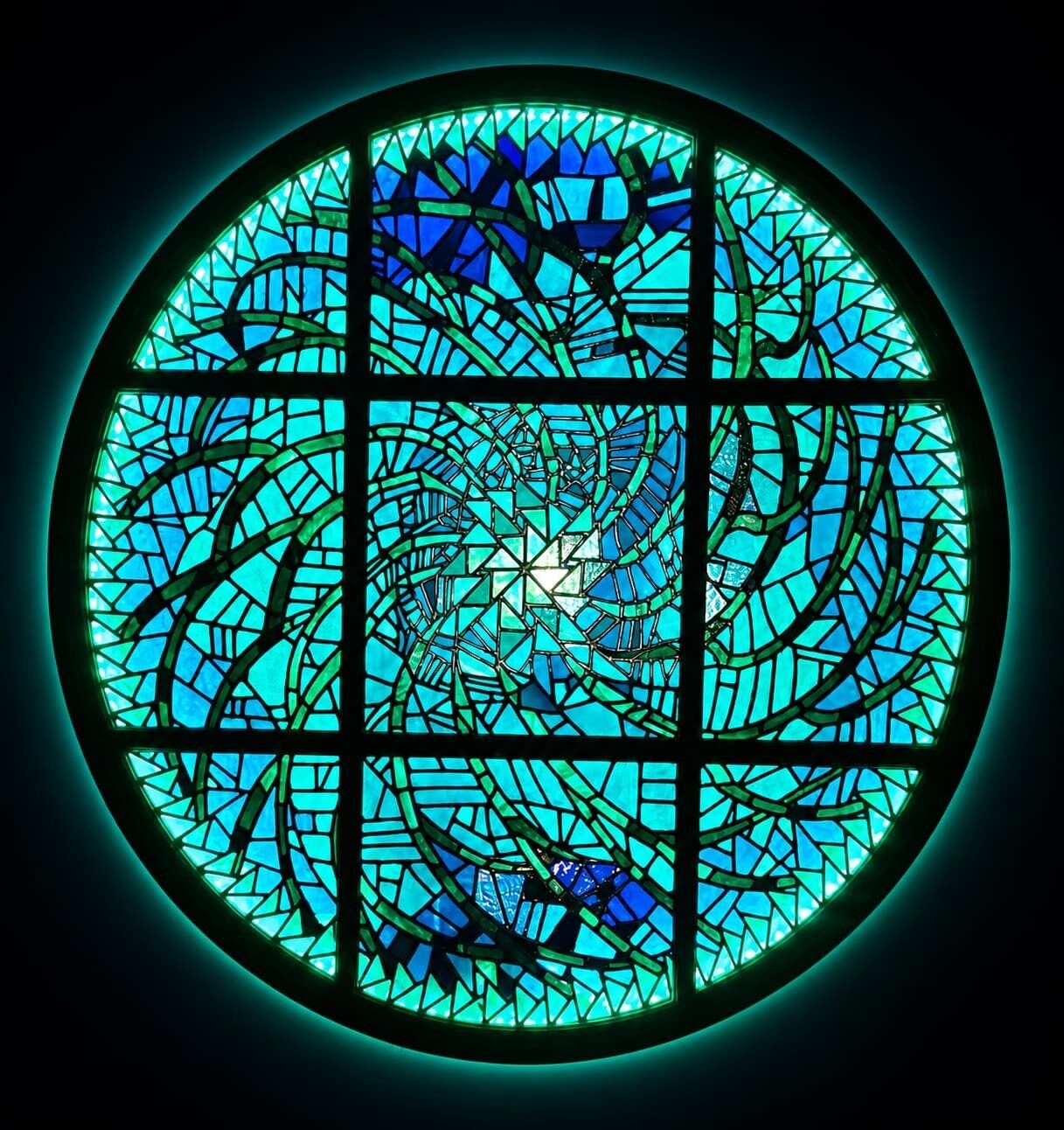 A circular stained glass window with a geometric pattern.