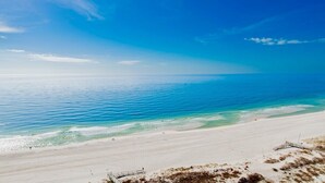 A beach with clear blue water and a sandy shore. - Turquoise Place C1501 | Gorgeous Updates! Oversized, hot tub/grill on deck, huge slide for kids! (Orange Beach)