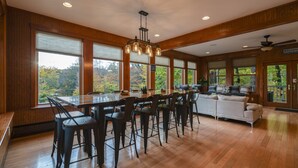 A spacious kitchen with a large island, wooden flooring, and large windows offering a view of the outdoors. - Babcock Lake Luxury Retreat: Direct Waterfront, Deck & Huge Game Room (Petersburgh)