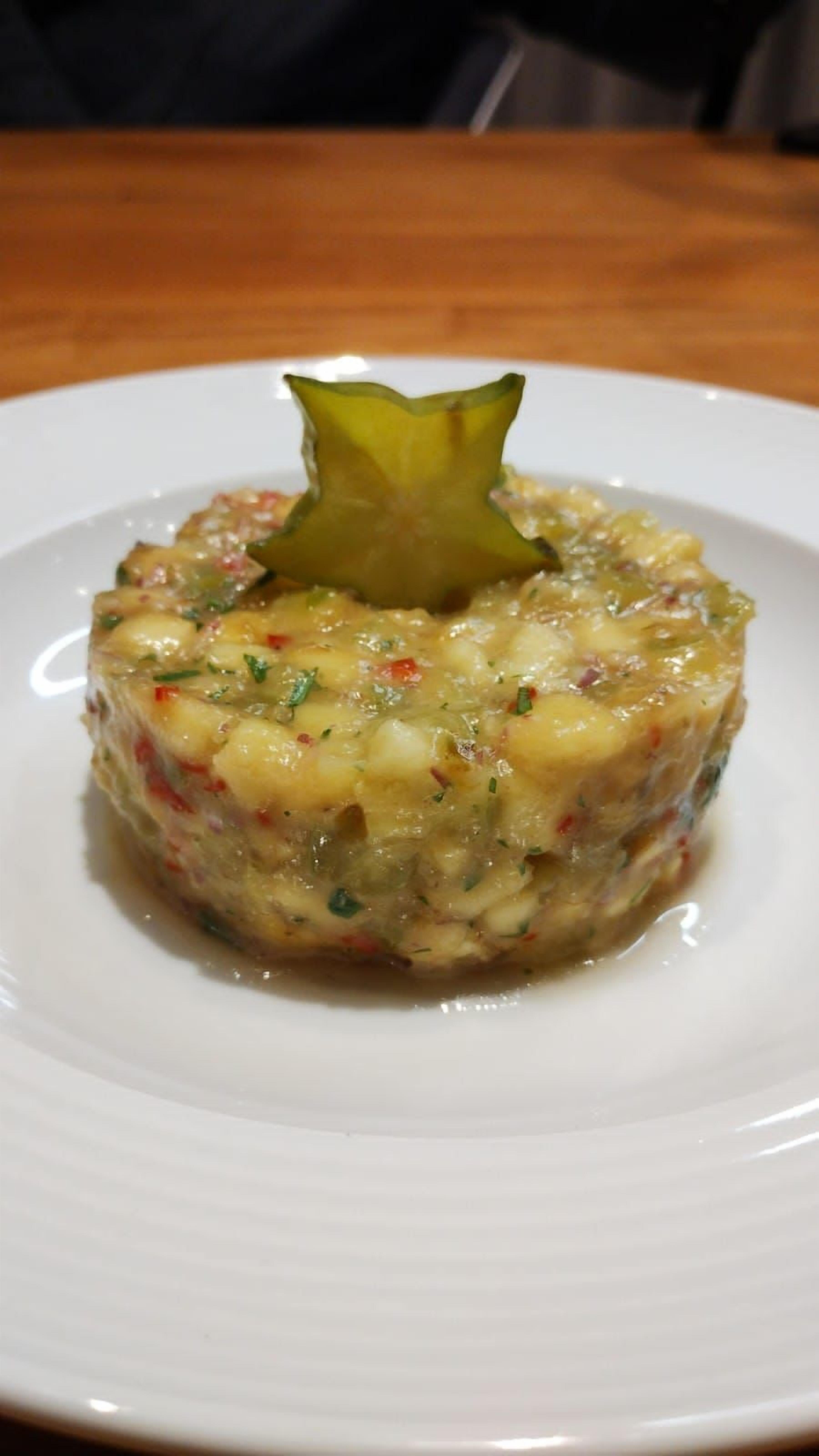 A plate with a food item, possibly a tart or pie, garnished with a star-shaped vegetable on top.