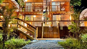 A two-story wooden lodge with a balcony, a staircase, and a sign reading "ILHA DO MEL LODGES". - Ilha do Mel Lodges (Paranaguá)