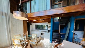 A modern interior with a dining area, kitchen, and living space. - Ilha do Mel Lodges (Paranaguá)