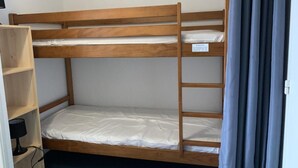 A bunk bed with a wooden frame and a shelf unit beside it. - Floor -1, view ski slopes, jacuzzi, hammam, balcony, parking, tv, 30m², Peyragudes (Germ)