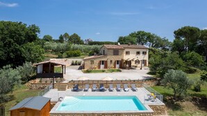 A two-story stone house with a swimming pool, outdoor seating, and a garden. - Casa La Fenice 8+2, Emma Villas (Pomarance)