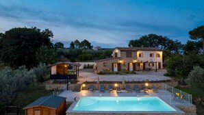 A two-story stone house with a swimming pool, outdoor seating, and a garden. - Casa La Fenice 8+2, Emma Villas (Pomarance)