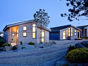 A modern two-story house with a gravel driveway, wooden siding, and large windows. - 2 bedroom accommodation in Carbis Bay, near St Ives (Carbis Bay, near St Ives)