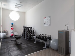 A gym with exercise equipment, a water dispenser, and a poster on the wall. - 2 bedroom accommodation in Carbis Bay, near St Ives (Carbis Bay, near St Ives)
