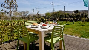 An outdoor dining area with a table set for breakfast, surrounded by greenery and a clear sky. - 2 bedroom accommodation in Carbis Bay, near St Ives (Carbis Bay, near St Ives)