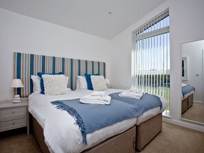A bedroom with a large bed, a bedside table, a mirror, and a view of the outdoors. - 2 bedroom accommodation in Carbis Bay, near St Ives (Carbis Bay, near St Ives)