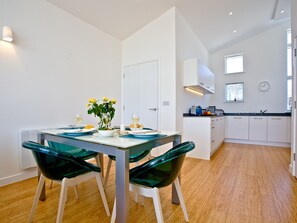 A modern kitchen with white cabinets, a built-in oven, and a window.