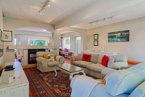 Uma sala de estar com lareira, um sofá, uma mesa de centro e um tapete.