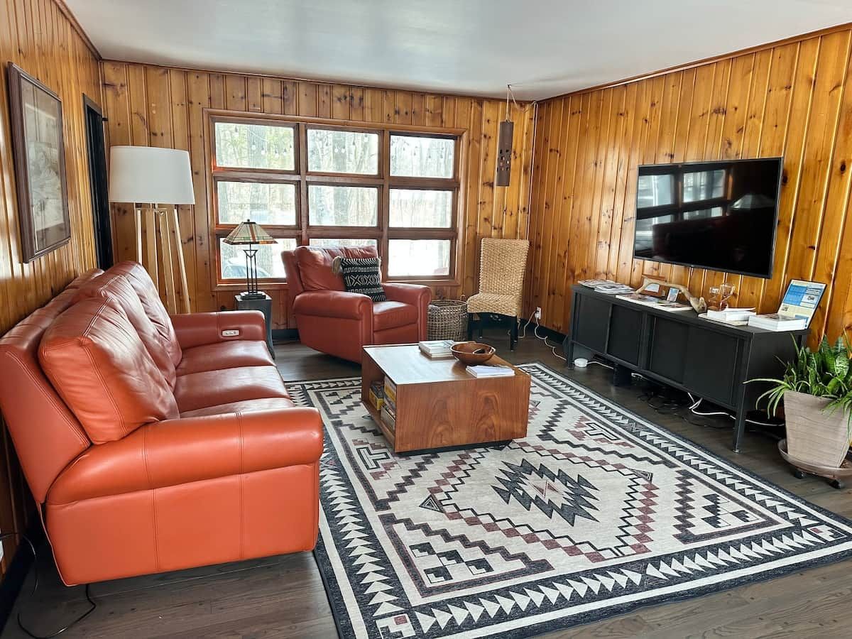 Een woonkamer met een leren bank, een salontafel en een televisie.