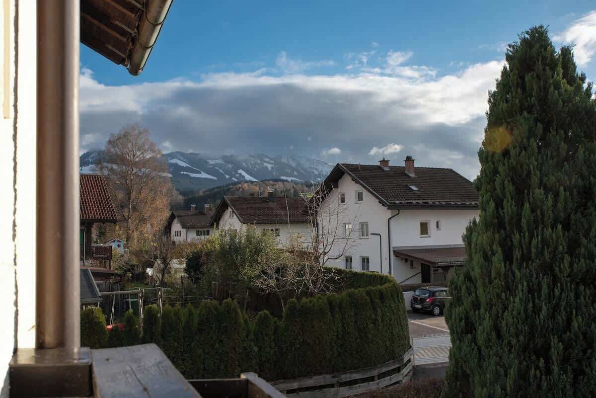 Zona residencial con casas, un automóvil estacionado y una montaña al fondo.