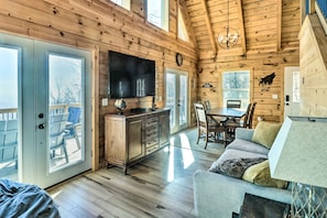 Relax in a cozy cabin with a large TV, dining area, and comfortable seating for socializing and unwinding.