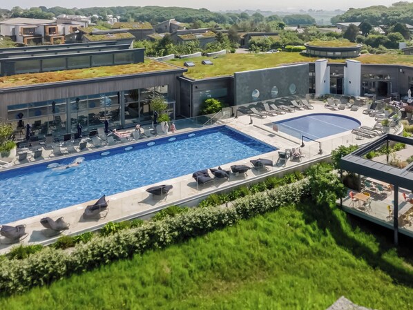 A rooftop swimming pool with lounge chairs and a separate pool area.