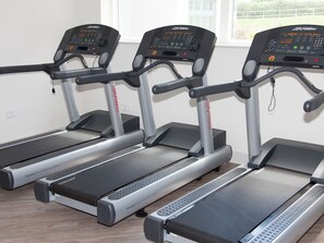 Three treadmills with digital displays, arranged in a row. - 2 bedroom accommodation in Carbis Bay, near St Ives (Carbis Bay, near St Ives)